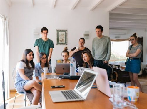 pexels-photo-1595385-1595385 Group of young professionals engaged in a collaborative meeting in a modern office setting.